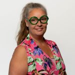 Team artra – vrouw met groene bril en roze blouse met bloemenmotief