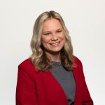 Team artra – vrouw in rood colbert met donkergrijs shirt en blond haar