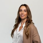 Team artra – vrouw met lang bruin haar in witte blouse en beige vest