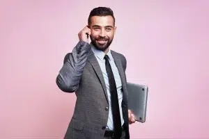 Zakelijke professional met laptop en telefoon als symbool voor kennis en sales voor detacheerders.