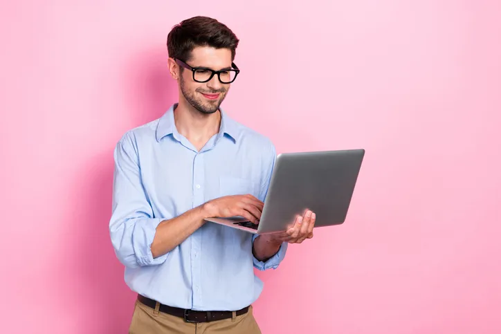 Glimlachende man die naar zijn laptop kijkt. Symbool voor het lezen van het wetsvoorstel