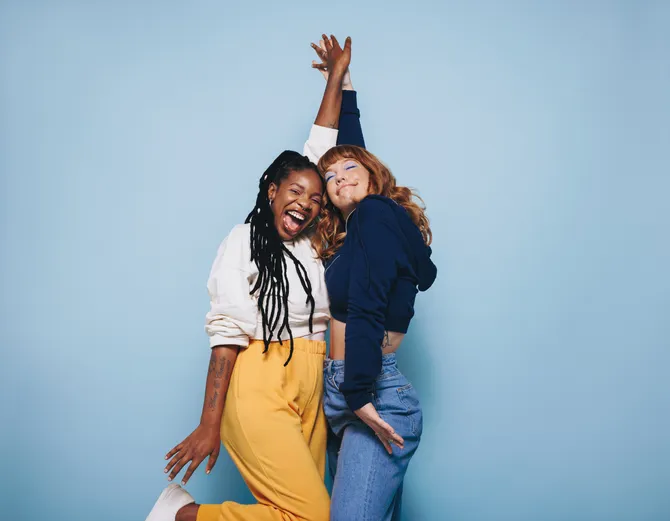 Twee jonge vrouwen van Gen Z die een enthousiaste high-five geven als symbool voor hun werkgeluk