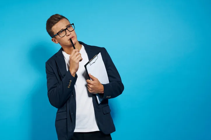 Jonge man die peinzend naar boven kijkt als symbool van het bedenken van werkende interviewtechnieken