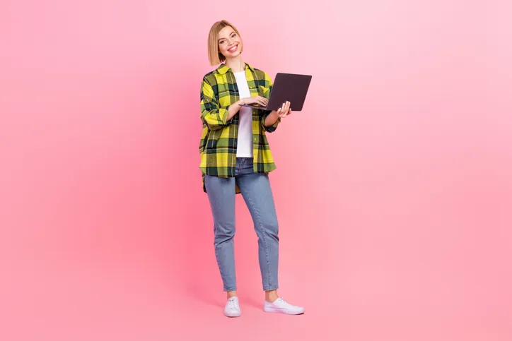 Jonge lachende vrouw met laptop als symbool voor het bekijken van de artra modulair webpagina