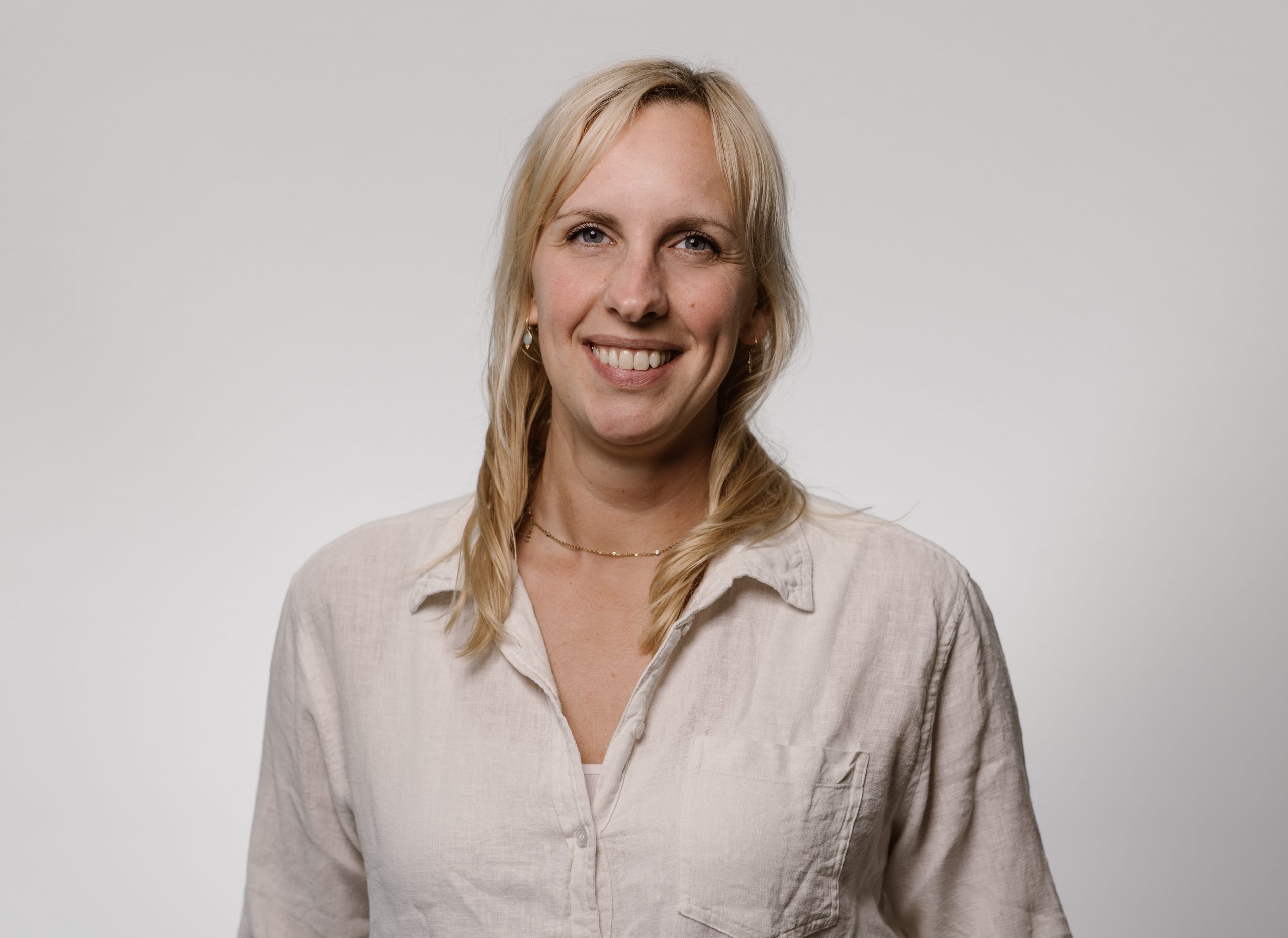 Team artra – vrouwelijk teamlid in beige blouse met blonde haren voor lichte achtergrond