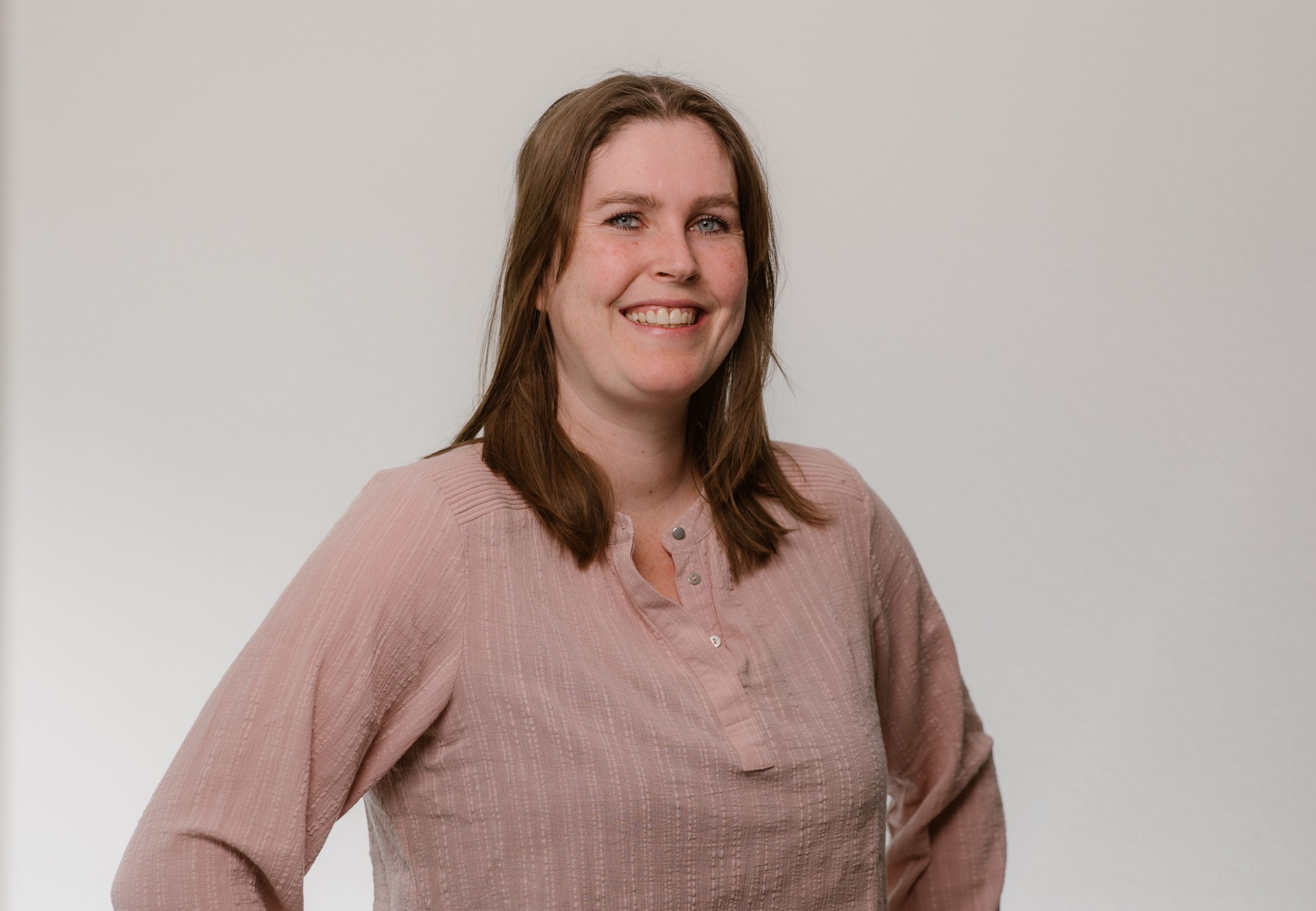 Team artra – vrouw in oudroze blouse poseert glimlachend