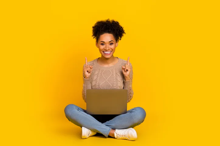 Jonge, lachende vrouw met laptop als symbool voor werven via social media