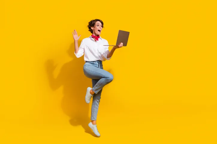 Enthousiaste vrouw met een laptop als symbool dat leren leuk is.