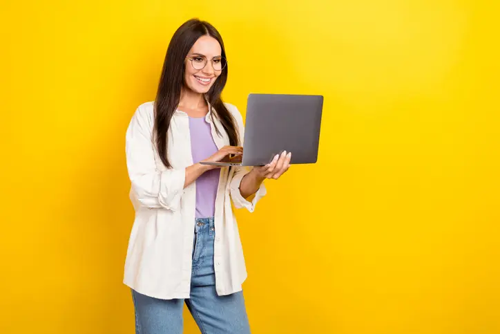 Jonge, professioneel uitziende vrouw met een laptop in haar handen als symbool voor een recruitment professional