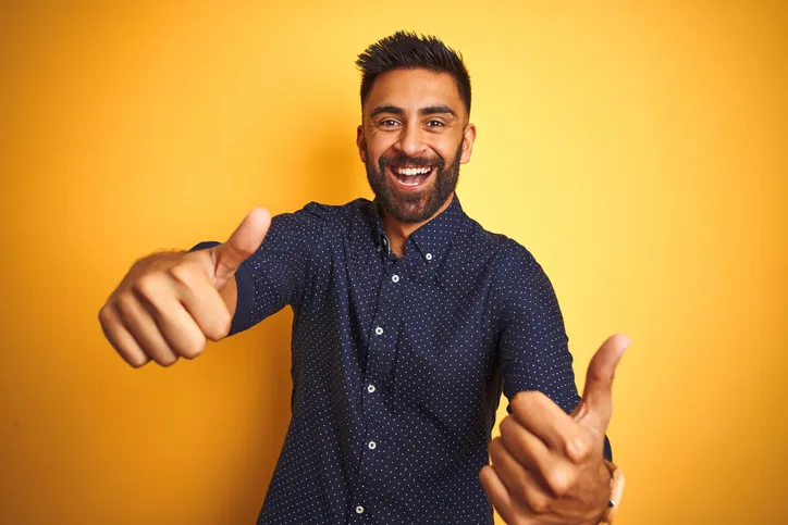 Lachende jonge man met duimen omhoog als enthousiast symbool voor de verkiezing van de Meest Invloedrijke Recruiter 2025