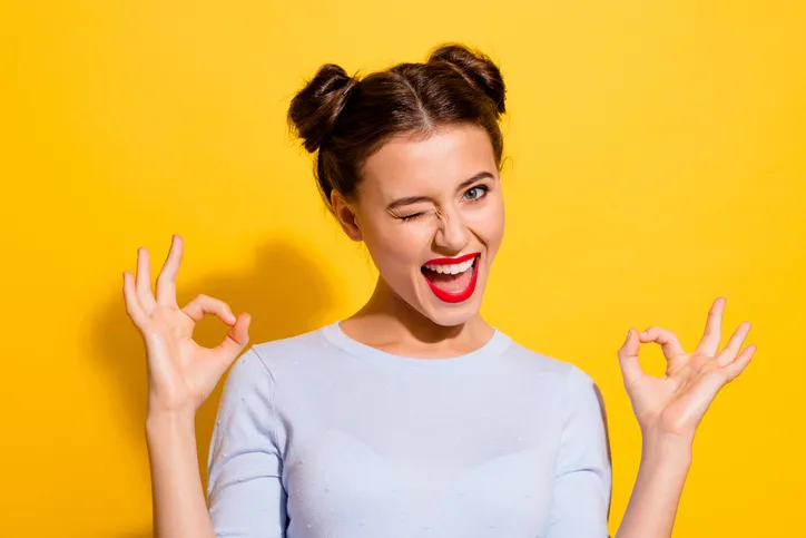 Jonge vrouw die lacht en knipoogt als symbool voor blij zijn met een sterke employer branding