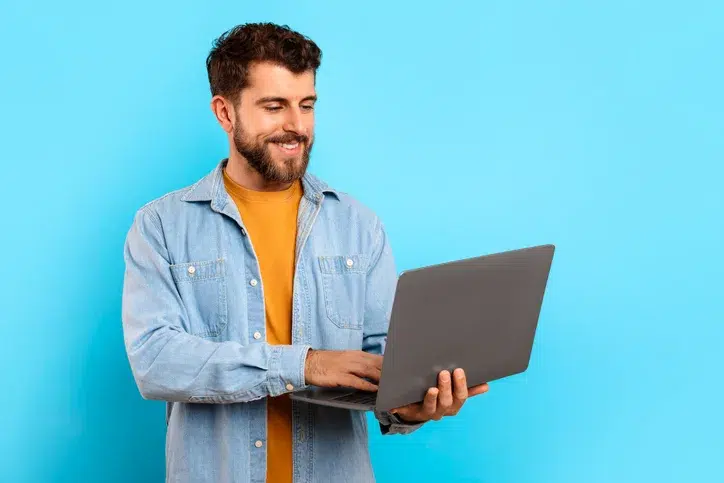 lachende man met laptop in zijn hand als symbool voor commerciële kracht