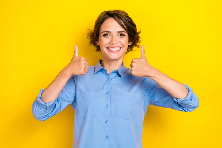 Positieve lachende vrouw met haar duimen omhoog als symbool voor enthousiasme over inclusief werken