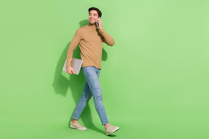 Jonge man met laptop en telefoon als symbool voor op de hoogte blijven van veranderingen in regelgeving
