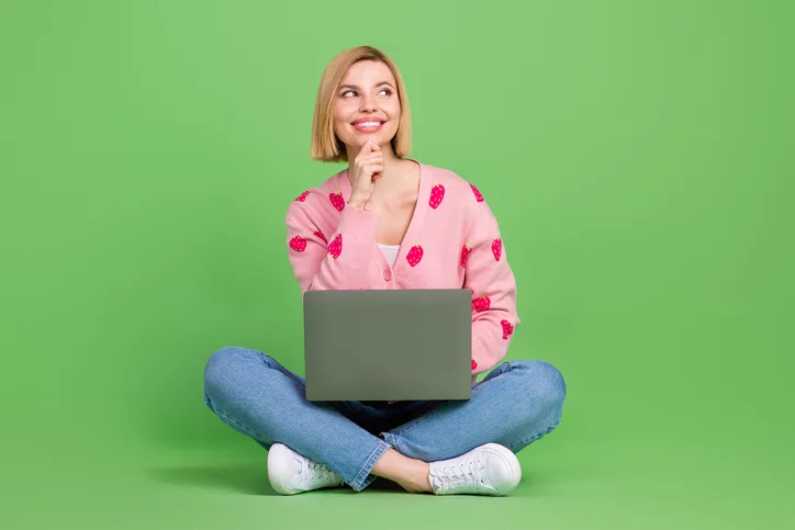 Jonge vrouw met laptop op schoot als symbool voor detacheren in een hybride tijdperk
