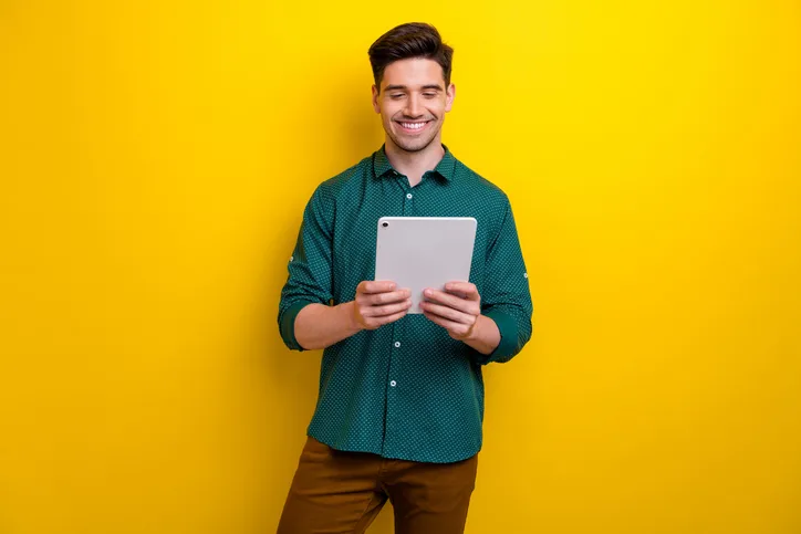 Jonge man met tablet als symbool voor het lezen van een motivatiebrief