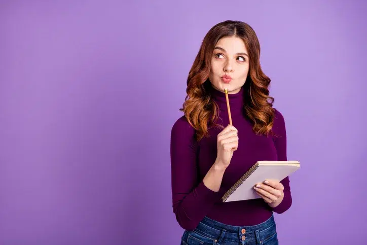 Jonge vrouw met notitieblok als symbool voor HR medewerker die zicht bezighoudt met vertrek van personeel