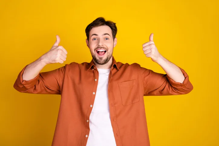 Jonge, enthousiaste man met zijn duimen omhoog als symbool voor flexibel opleiden in een krappe arbeidsmarkt