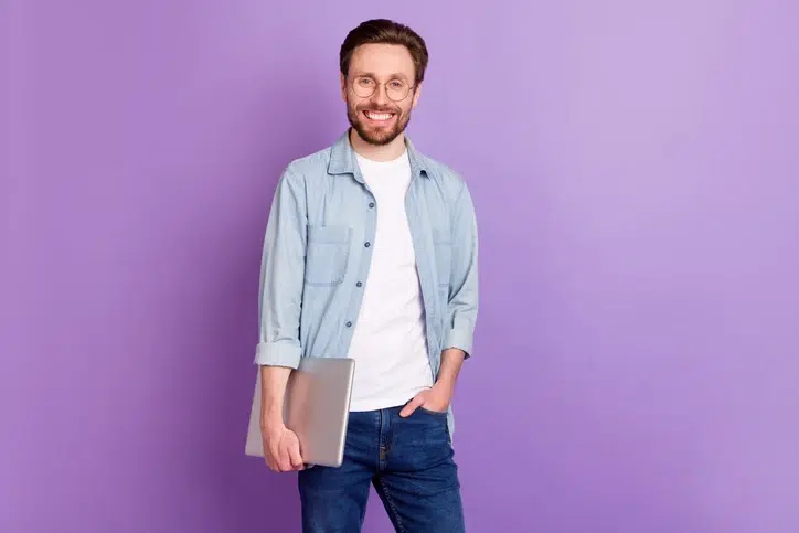 Lachende man met laptop als symbool voor de het implementeren van modulair leren