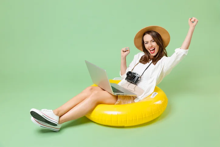 Jonge vrouw in zomerse kleding met laptop als symbool van recruitment in de zomerperiode