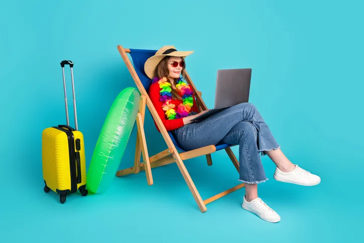 Jonge vrouw die met haar laptop in een strandstoel zit als symbool voor HR-professionals die verzuim en uitval voorkomen na de zomer
