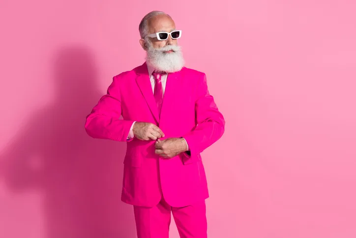Oudere man in roze pak als symbool voor een senior professional