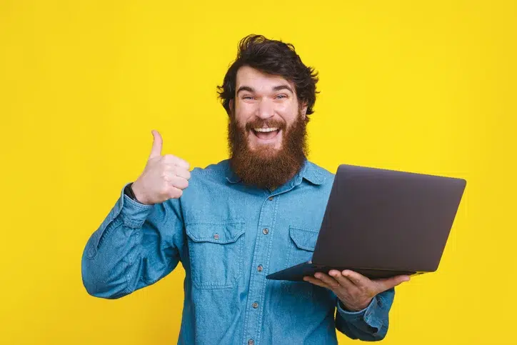 Enthousiaste man mat laptop als symbool voor aandacht op het werk, en werken met focus.