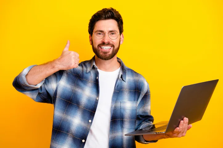lachende man met laptop als symbool van betrokkenheid van de detacheerder na de plaatsing